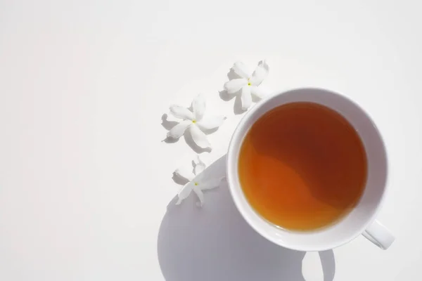 Tasse Tee und drei weiße Blumen — Stockfoto