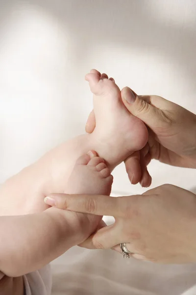 Handen houden de voeten van de baby's — Stockfoto