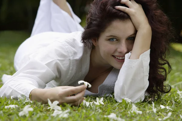 Vrouw op gras met witte bloesem — Stockfoto