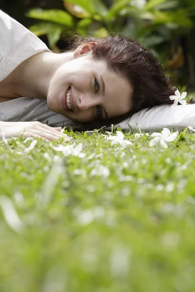 Femme sur herbe avec des fleurs blanches — Photo