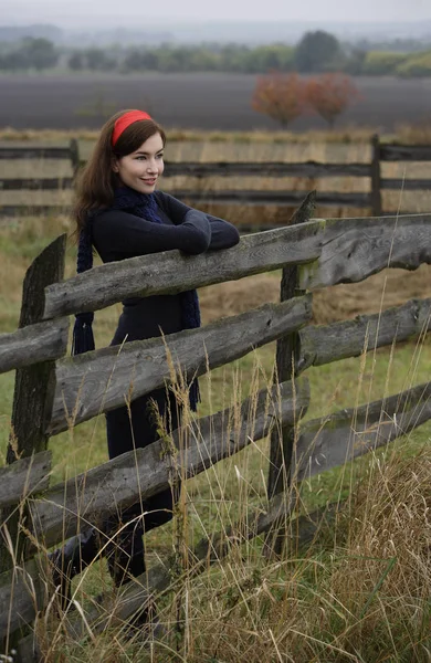 woman leaning on country fence