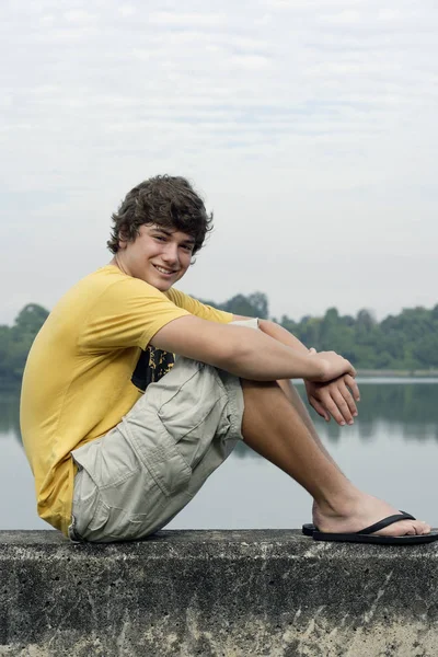 Ragazzo adolescente seduto sul muro — Foto Stock