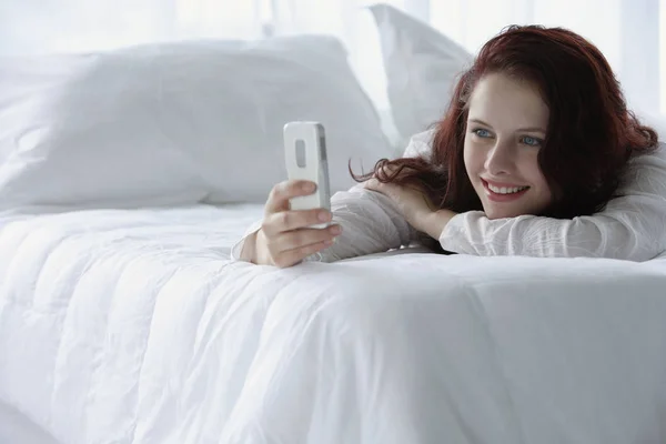 Mujer leyendo mensaje de texto y sonriendo —  Fotos de Stock