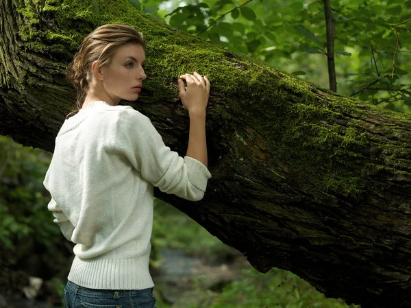 Vrouw leunend tegen boom — Stockfoto