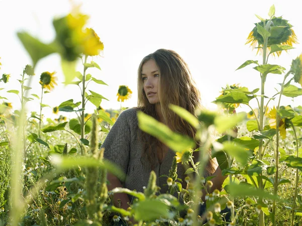 Jonge vrouw stond temidden van zonnebloemen — Stockfoto