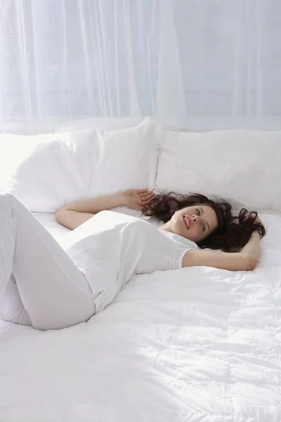 Mujer recostada en la cama —  Fotos de Stock