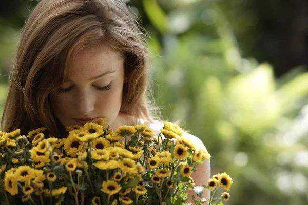 Young woman smelling big bunch of daisies — Stock Photo, Image