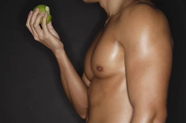 Uomo muscoloso nudo con mela — Foto Stock