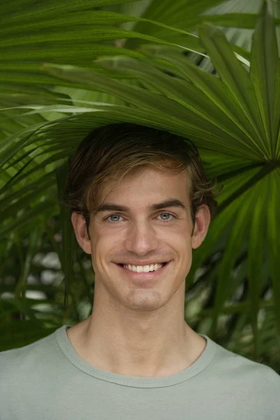 Porträtt av ung man under tropiska träd — Stockfoto