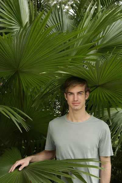 A fiatalember állt trópusi növények — Stock Fotó