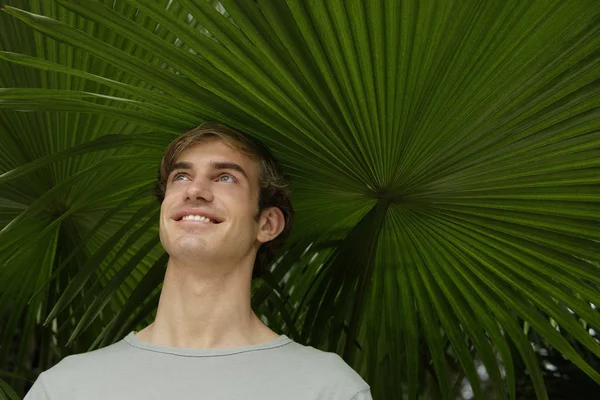 Trópusi fa alatt fiatalember portréja — Stock Fotó