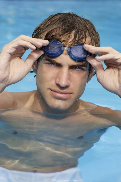 Jeune homme dans la piscine avec des lunettes — Photo