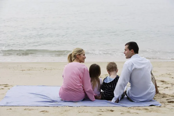Семья на одеяле на пляже — стоковое фото
