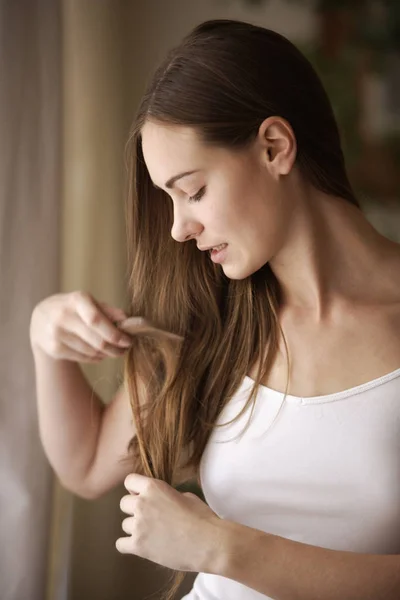 Mujer joven peinando el cabello — Foto de Stock