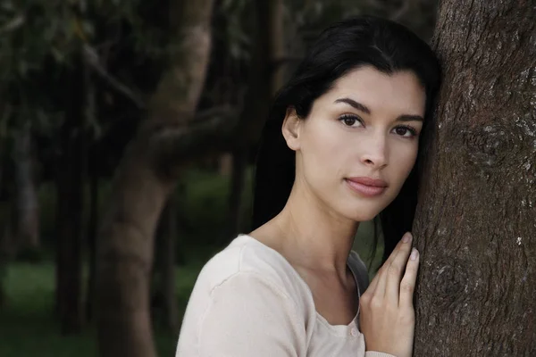 Vrouw leunend tegen boom — Stockfoto