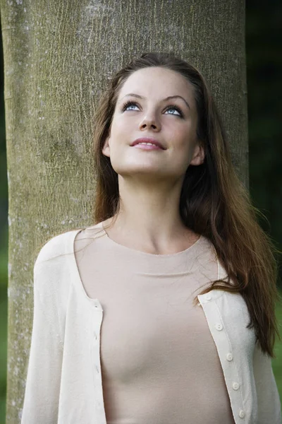 Portret van de vrouw leunt tegen boom opzoeken. — Stockfoto