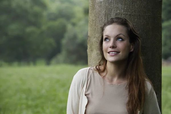 Vrouw leunend tegen boom. — Stockfoto