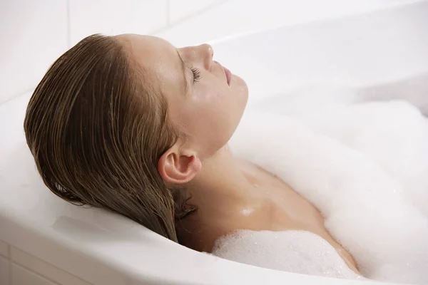 斜躺在浴缸里的女人 — 图库照片