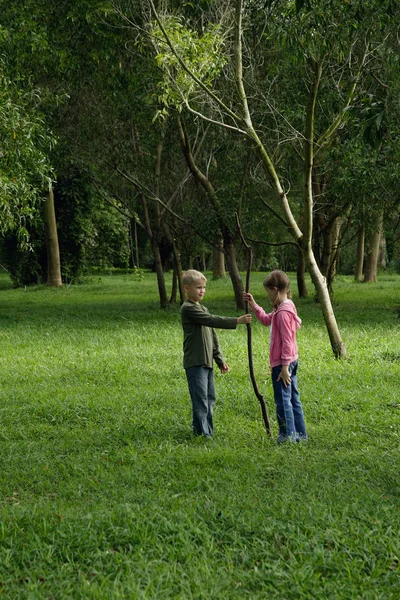 Pojke och flicka holding stick — Stockfoto