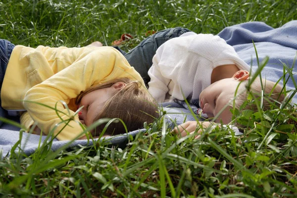 Irmão e irmã deitados em cobertor — Fotografia de Stock