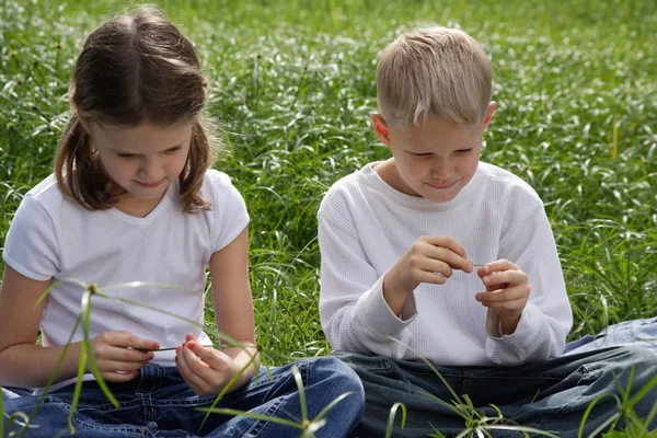 Kinder sitzen auf Gras im Park — Stockfoto