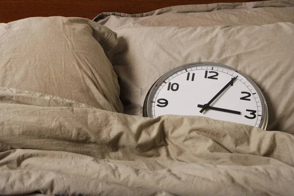 Large clock in a bed. — Stock Photo, Image