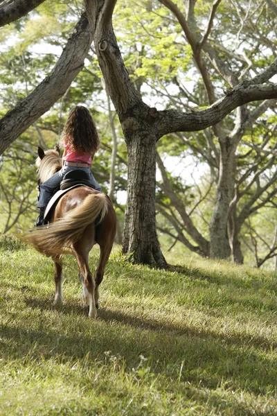 Chica joven cabalgando lejos en pony — Foto de Stock