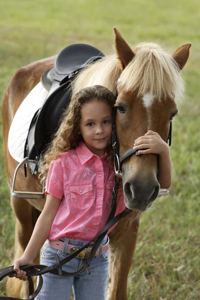 Young girl hugging nose of pony — Stock Photo, Image