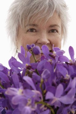 Mature woman holding orchids clipart
