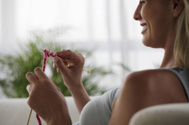 Young pregnant woman knitting clipart