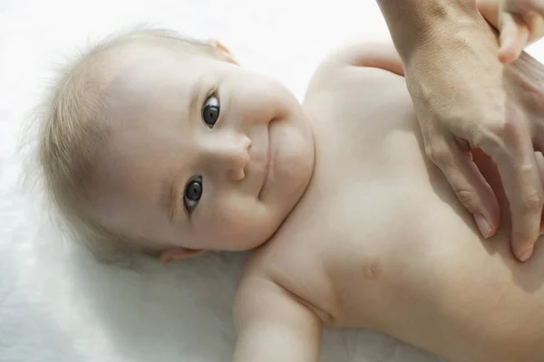 Main mère touchant le corps du bébé — Photo