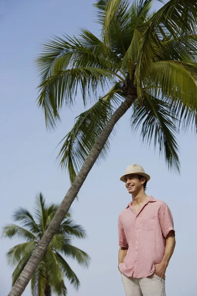 Mann steht unter Palmen — Stockfoto