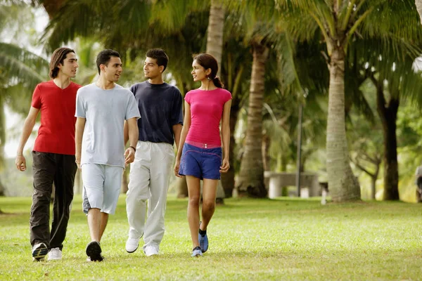 Giovani adulti che camminano nel parco — Foto Stock