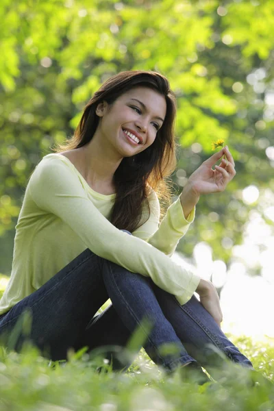 Jonge vrouw zittend op gras — Stockfoto