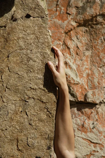 female hand on rock