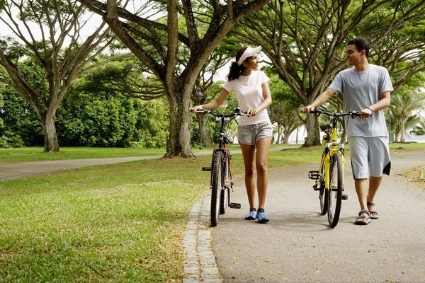 夫妇在公园里，牵着自行车 — 图库照片