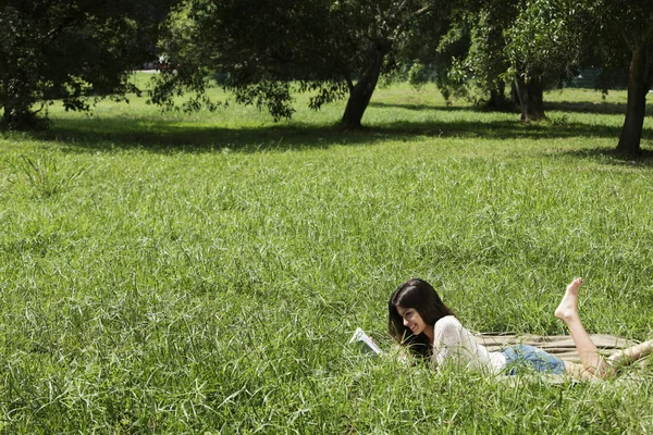 Γυναίκα στο γρασίδι, διαβάζοντας ένα βιβλίο — Φωτογραφία Αρχείου