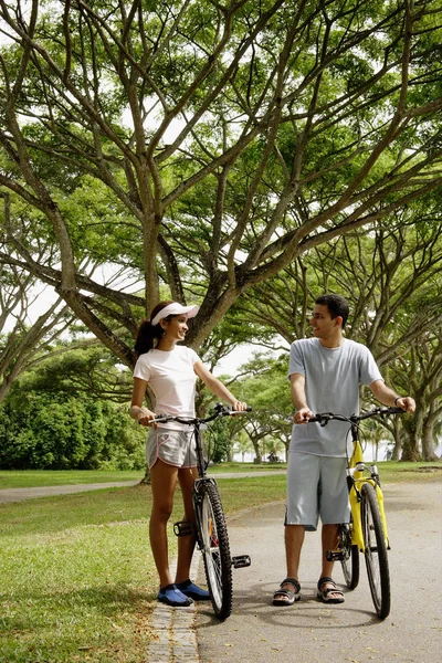 Pareja de pie con bicicletas — Foto de Stock