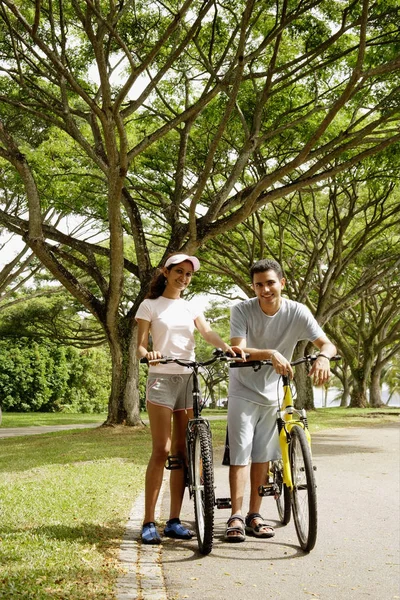 Pareja de pie con bicicletas — Foto de Stock