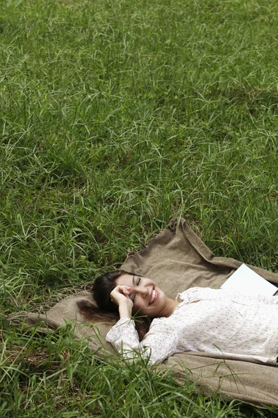 Jonge vrouw liggend op gras — Stockfoto