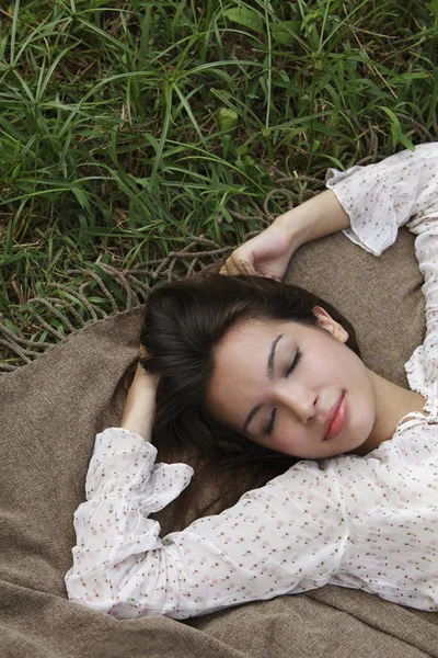 Mujer joven acostada en la hierba — Foto de Stock