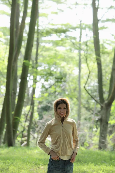 Mujer joven de pie frente a los árboles —  Fotos de Stock
