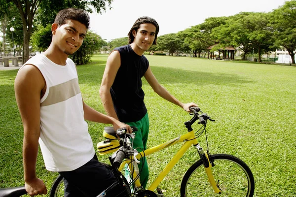 Due giovani in bicicletta nel parco — Foto Stock