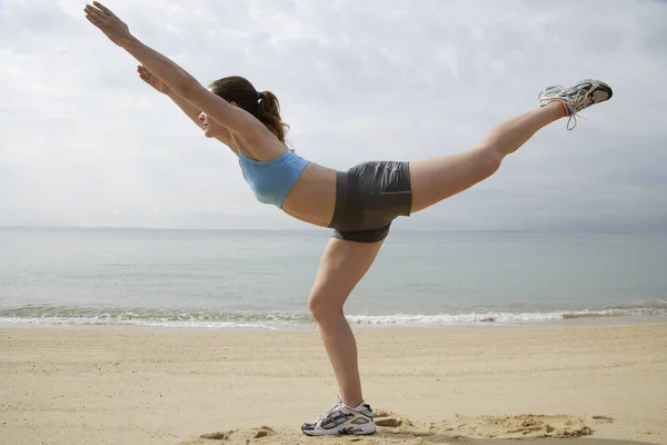 Woman stretching on beach — Stock Photo, Image