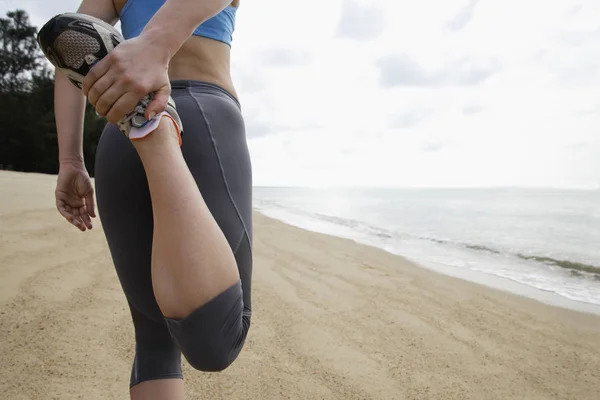 Woman stretching on beach — Stock Photo, Image