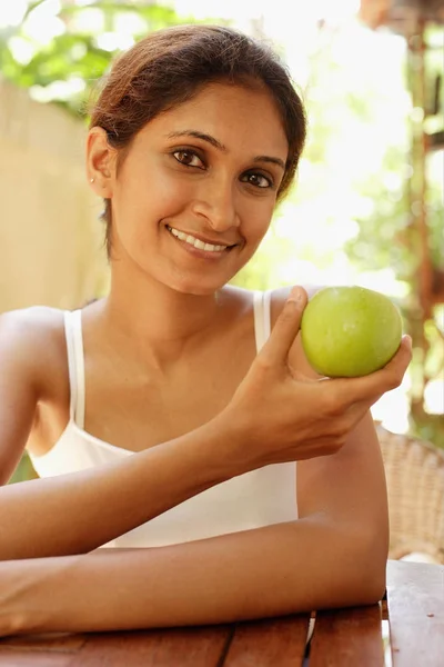 woman holding apple and smiling