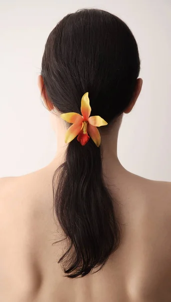 Žena s květinou ve vlasech — Stock fotografie