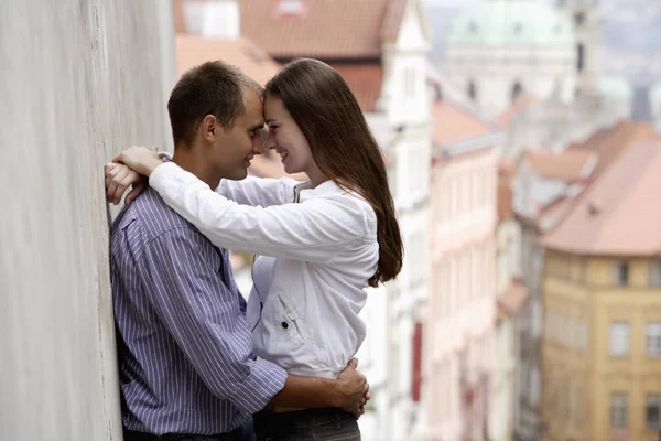 Jovem casal abraçando ao lado da parede — Fotografia de Stock