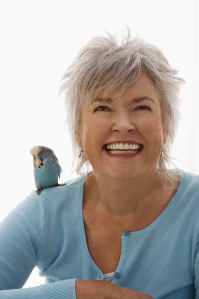 Mujer mayor con pájaro azul — Foto de Stock