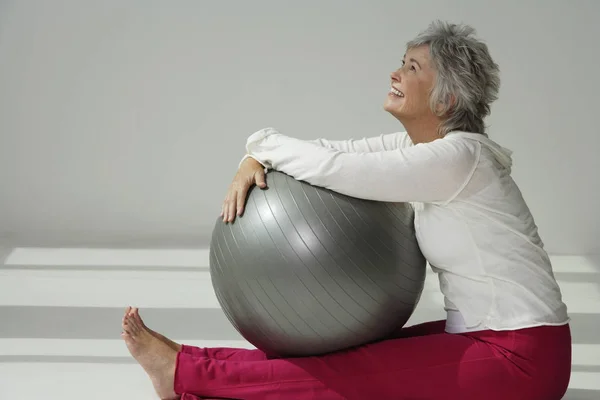 Mujer sosteniendo la bola de ejercicio — Foto de Stock